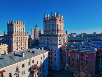 Buildings in city against blue sky