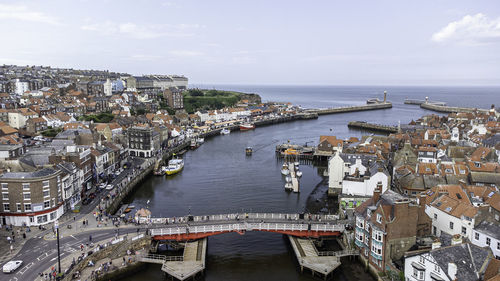 High angle view of buildings by sea against sky