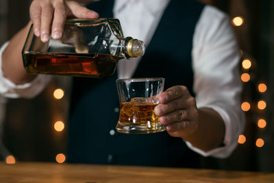 Close-up of man pouring wine in glass
