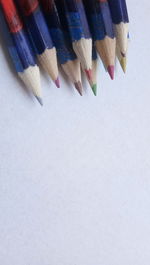 High angle view of multi colored pencils on white background