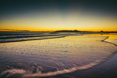 View of calm beach at sunset