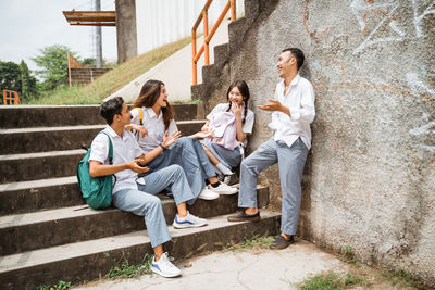 Full length of friends sitting on steps