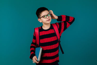 Young man standing against blue background