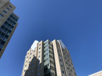 Low angle view of modern buildings against clear blue sky