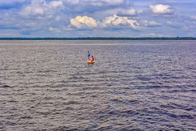 Rear view of man in sea against sky