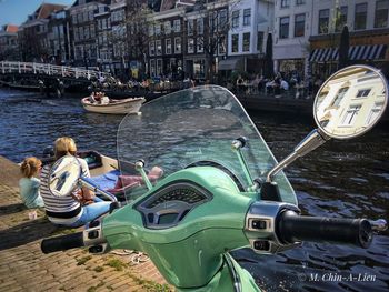 People on boats in canal along buildings