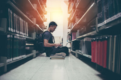 Full length of young man looking at book