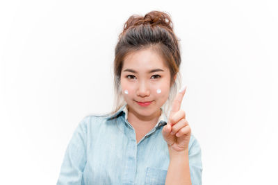 Portrait of smiling young woman against white background