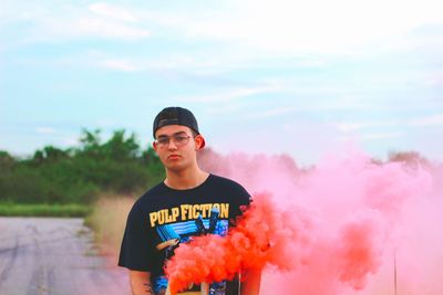 Portrait of young man standing against sky