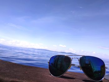 Sunglasses on beach against sky