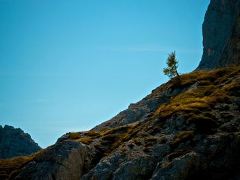 Low angle view of rock formation against clear blue sky