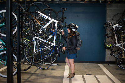 Young woman grabbing bike from bike storage