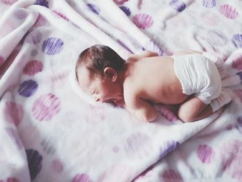 High angle view of baby lying on bed