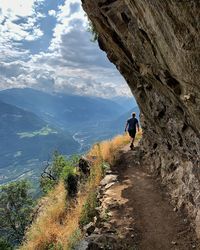 Rear view of man on rock by mountains