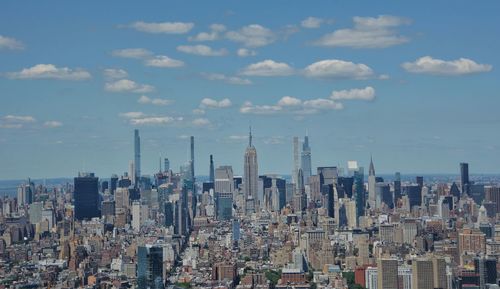 Aerial view of modern buildings against cloudy sky