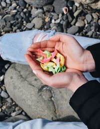 Midsection of woman holding paper boats at beach