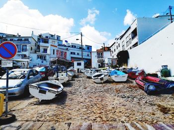 Cars on street by buildings against sky