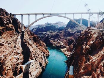 Aerial view of bridge over river against cloudy sky