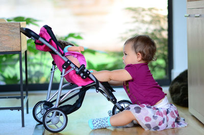 Portrait of boy playing with push scooter in gym