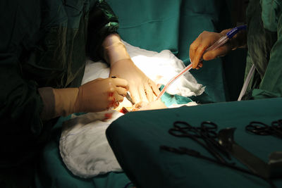 Midsection of surgeons operating patient in hospital