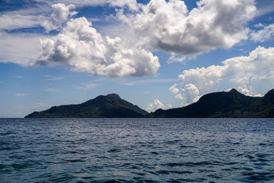 Scenic view of sea and mountains against sky