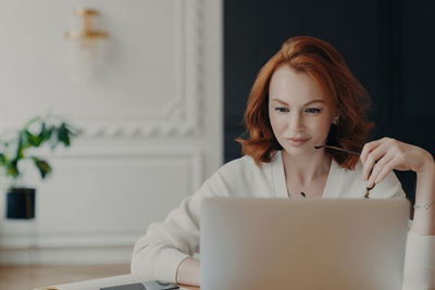 Young woman using laptop at home