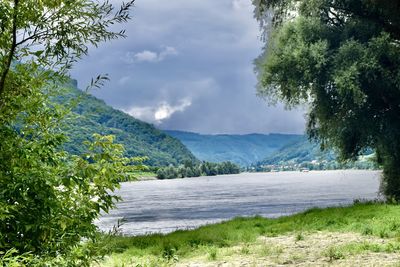 Scenic view of lake by mountains against sky