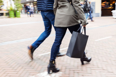 Low section of people walking on street