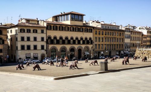 People on street against buildings in city