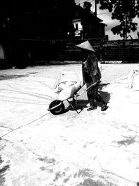 Woman sitting on street in city during winter