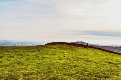 Scenic view of field against cloudy sky