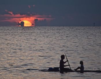 Silhouette of man in sea at sunset