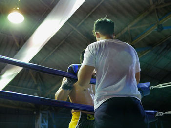 Rear view of man standing by railing