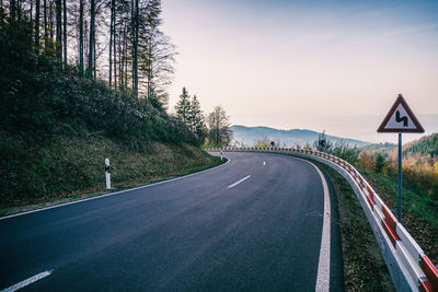 Sign saying curvy road in the black forest with view into the rhine valley