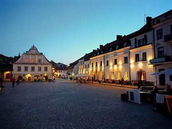 Street amidst buildings against clear sky at dusk