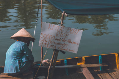 Rear view of woman with umbrella in lake