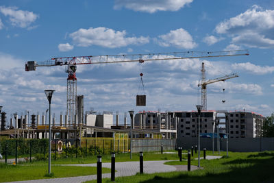 Cranes against sky in city