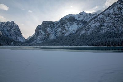 Scenic view of lake and snowcapped mountains against sky