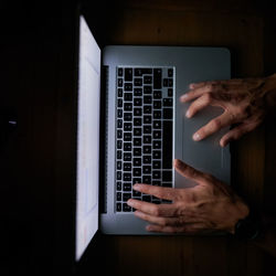 Cropped hand using laptop