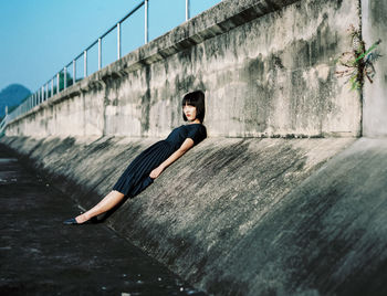 Full length portrait of woman standing by railing