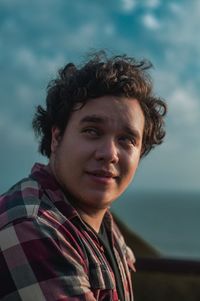 Portrait of young man against sky