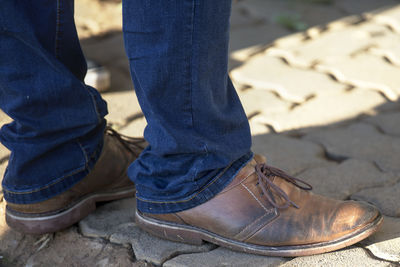 Low section of man sitting on footpath