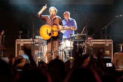 People playing guitar at music concert