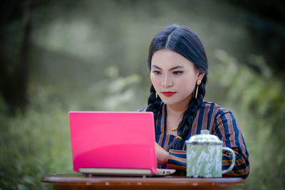 Portrait of young woman using digital tablet