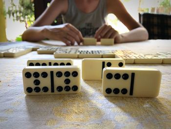 Midsection of woman playing domino on table