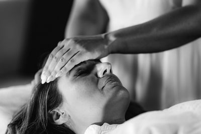 Reiki healing. woman lying with her eyes closed, having treatment.