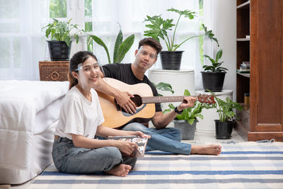 Young couple sitting on potted plant