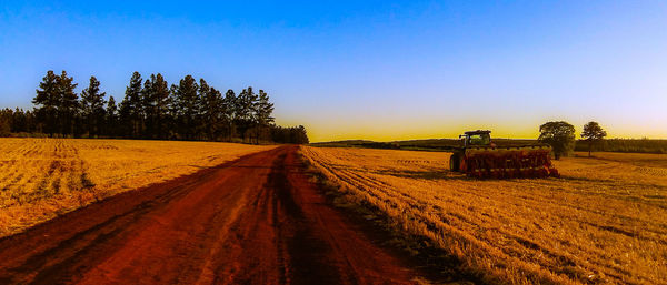 Scenic view of agricultural field against sky during sunset