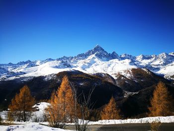 Snow covered mountains against clear blue sky