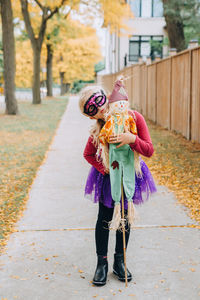 Cute girl wearing costume standing on footpath